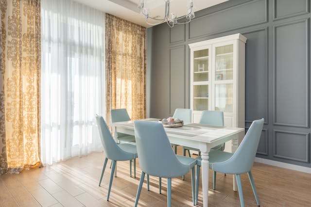 elegant-dining-room-with-a-white-table-blue-chairs-and-a-glass-front-cabinet