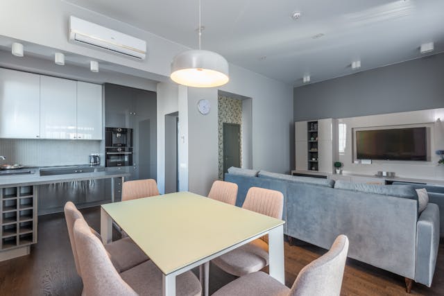 modern-open-living-space-with-dining-table-gray-sofa-tv-and-sleek-kitchen